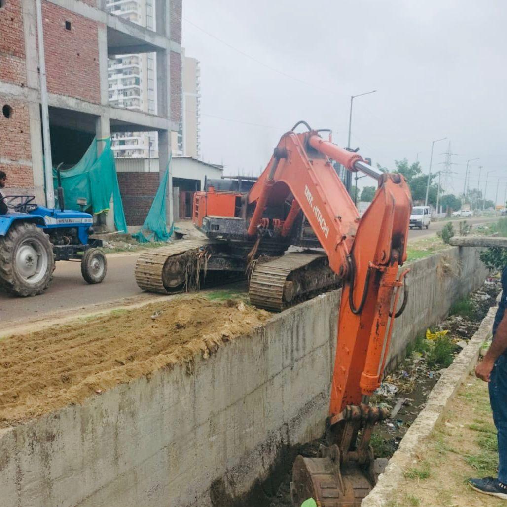 Greater Noida News: ग्रेटर नोएडा में ड्रेन सफाई अभियान जोरों पर, निवासियों से प्लास्टिक कचरा न फेंकने की अपील
