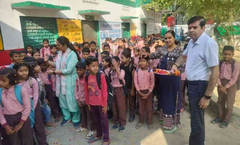Greater Noida News : फूलों की बारिश, टीका और नई किताबों के साथ हुआ भव्‍य स्‍वागत, नए सत्र में छाया उत्‍साह, बच्‍चों के चेहरे पर दिखी खुशी, छात्रों को अनुशासन और मेहनत का पाठ पढ़ाया